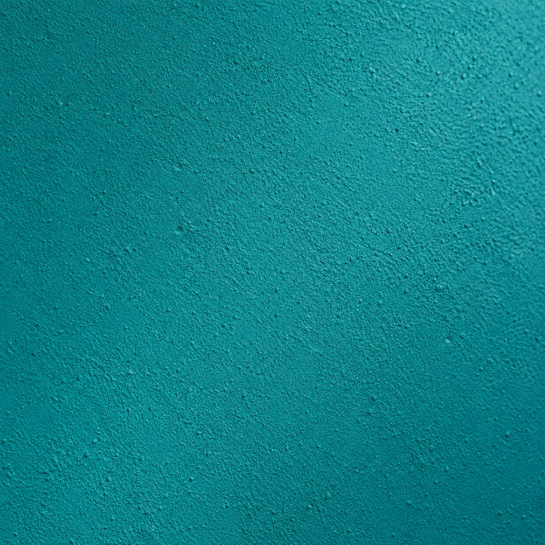 Macro photograph of matt turquoise paint with fine plaster grain
